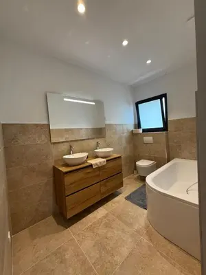 a bathroom with two sinks and a tub and a toilet at Chez Claudine & Adrien in Figari