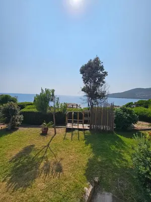 a yard with a playground with a fence and the ocean at Bella Stella in Coggia