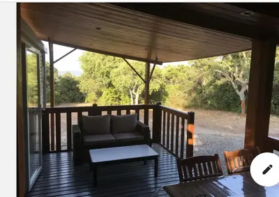 a screened in porch with a couch and a table at Chalet cosy in Pianottoli-Caldarello