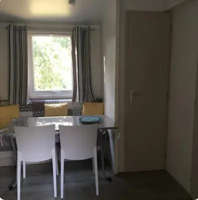 a dining room with a table and chairs and a window at Chalet cosy in Pianottoli-Caldarello