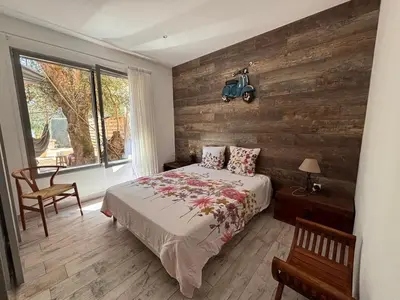 a bedroom with a bed and a wooden wall at Le Refuge du Maquis in Bonifacio