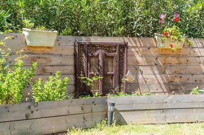 a wooden wall with a door and some plants at Le Refuge du Maquis in Bonifacio
