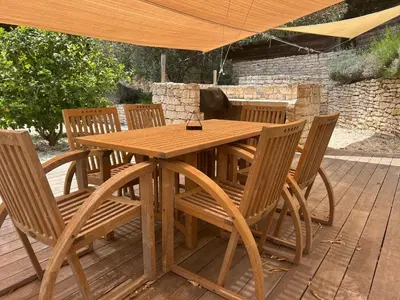 a wooden table and chairs on a wooden deck at Vacances Bonifacio Bergerie in Bonifacio