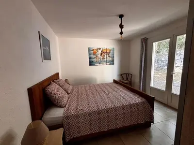 a bedroom with a bed and a window at La Villa Maquis in Bonifacio