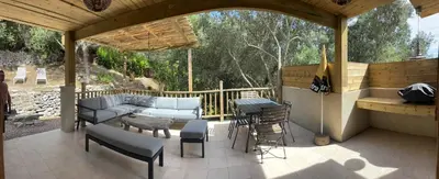 a patio with a couch and a table and chairs at La Villa Maquis in Bonifacio
