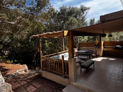 a wooden deck with a table and a bench at La Villa Maquis in Bonifacio