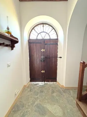 a large wooden door in a room with a window at L'appartement Montecristo in Aléria