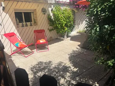 two red chairs sitting next to a house at Le Maquis in Alata