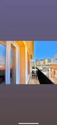 a balcony with a table and a view of a city at Appartement Ajaccio private parking in Ajaccio