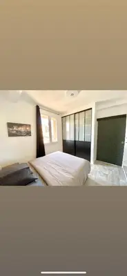 a bedroom with a large bed and a television at Appartement Ajaccio private parking in Ajaccio
