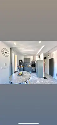 a kitchen with a table in the middle of a room at Appartement Ajaccio private parking in Ajaccio