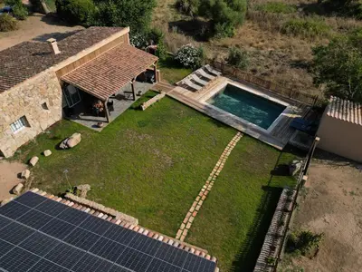an aerial view of a house with a swimming pool and solar panels at Villa in nature & heated pool - Figari in Figari