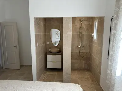 a bathroom with a shower with a sink and a mirror at Villa in nature & heated pool - Figari in Figari