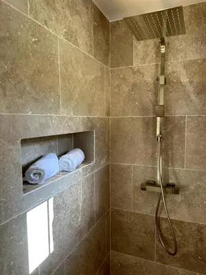 a bathroom with a shower with two towels on a shelf at Villa in nature & heated pool - Figari in Figari
