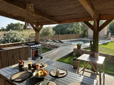 an outdoor patio with a table with food on it at Villa in nature & heated pool - Figari in Figari