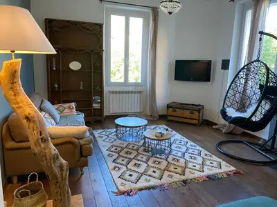a living room with a couch and a table at Au coeur de Sartène appartement de charme dans un écrin de verdure in Sartène