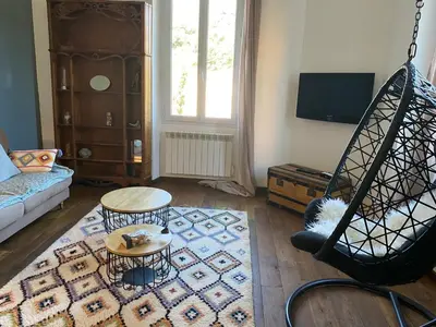 a living room with a couch and a swing at Au coeur de Sartène appartement de charme dans un écrin de verdure in Sartène
