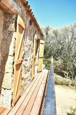 an open door to a stone building with wooden doors at Bergerie avec piscine chauffée Sotta in Sotta