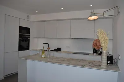 a kitchen with white cabinets and a counter top at Bergerie avec piscine chauffée Sotta in Sotta