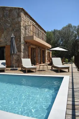 a house with a swimming pool in front of a building at Bergerie avec piscine chauffée Sotta in Sotta