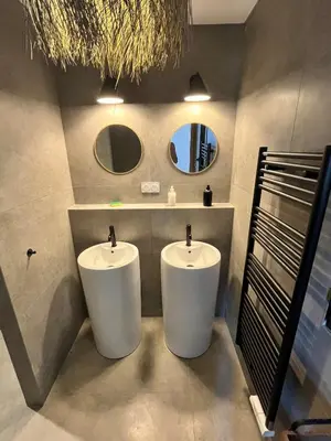 two white sinks in a bathroom with two mirrors at Bergerie avec piscine chauffée Sotta in Sotta