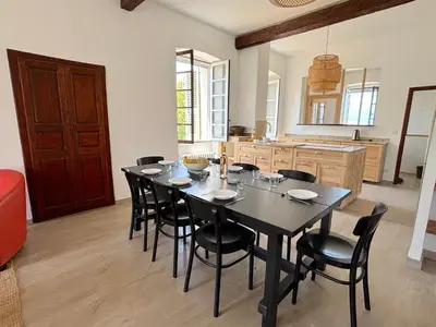 a dining room with a black table and black chairs at L'appartement Pianosa in Aléria