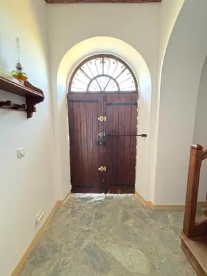 a large wooden door in a room with a window at L'appartement Pianosa in Aléria