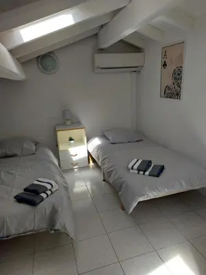 a room with two beds and a table with a lamp at Marina-Di-Pinarello Corse-du-Sud à 400m de la plage Pinarellu in Zonza