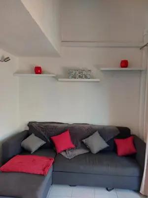 a couch with pillows on it in a room at Marina-Di-Pinarello Corse-du-Sud à 400m de la plage Pinarellu in Zonza