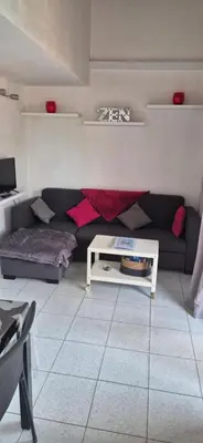 a living room with a couch and a table at Marina-Di-Pinarello Corse-du-Sud à 400m de la plage Pinarellu in Zonza