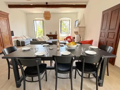 a dining room with a black table and chairs at L'appartement Montenosa in Aléria