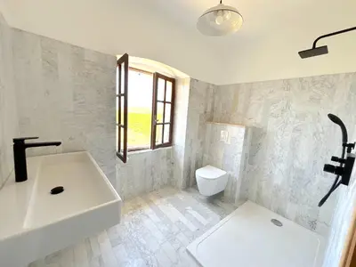 a white bathroom with a sink and a toilet at L'appartement Montenosa in Aléria