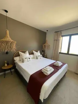 a bedroom with a large bed with towels on it at La Villa Geneviève, Maison 6 personnes avec piscine in Calenzana