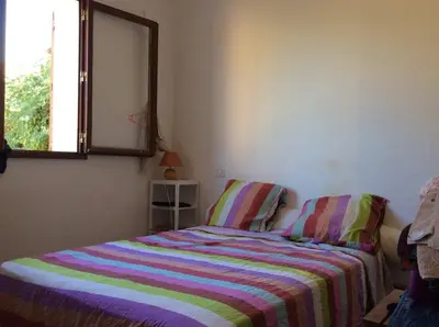 a bedroom with a bed with a striped blanket and a window at Casa di Purgu in Sotta