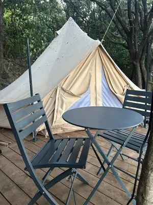 a table and two chairs and a tent at Tente Lodge avec Vue sur la Baie d'Ajaccio in Ajaccio