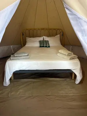 a bed in a tent with two towels on it at Tente Lodge avec Vue sur la Baie d'Ajaccio in Ajaccio
