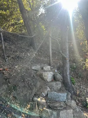 a stone path in a forest with a tree at Tente Lodge avec Vue sur la Baie d'Ajaccio in Ajaccio