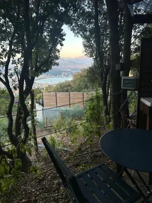 a table and chairs on a hill with a view at Tente Lodge avec Vue sur la Baie d'Ajaccio in Ajaccio