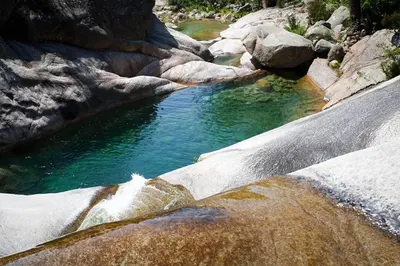 a pool of water in a river with rocks at Villa de charme au bord des piscines naturelles in Ventiseri