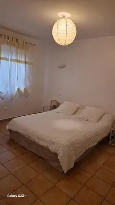 a bedroom with a large bed and a chandelier at Villa de charme au bord des piscines naturelles in Ventiseri