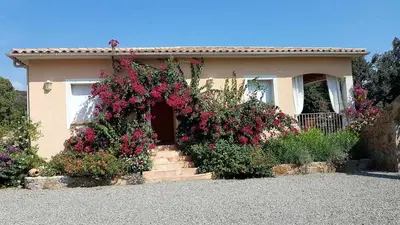 a house with a bunch of flowers in front of it at Villa de charme au bord des piscines naturelles in Ventiseri