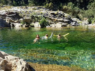 a group of people swimming in a river at Villa de charme au bord des piscines naturelles in Ventiseri