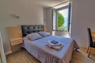 a bedroom with a bed and a large window at A Sant'Anna in Albertacce