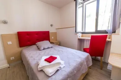 a bedroom with a red headboard and a red chair at A Sant'Anna in Albertacce