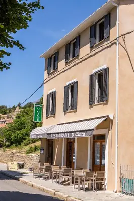 a building with tables and chairs in front of it at A Sant'Anna in Albertacce