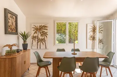 a dining room with a wooden table and green chairs at Villa Lisa Porto-Vecchio in Porto-Vecchio