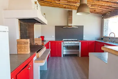 a kitchen with red cabinets and a stove at Villa Lisa Porto-Vecchio in Porto-Vecchio