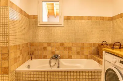 a bathroom with a tub with a sink and a window at Villa Lisa Porto-Vecchio in Porto-Vecchio