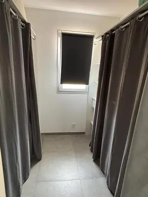 a bathroom with black curtains and a window at villa Morgane in Calenzana