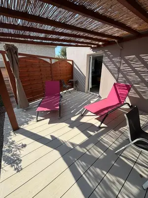 two pink chairs sitting on a wooden deck at villa Morgane in Calenzana